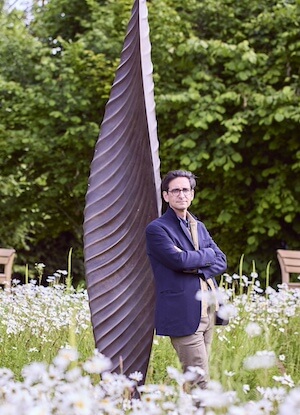 Lior Kristal with sculpture in the garden